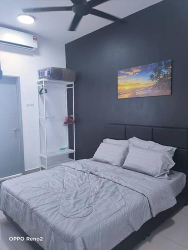 a bedroom with a large bed with a blue wall at The Second Homestay in Port Dickson