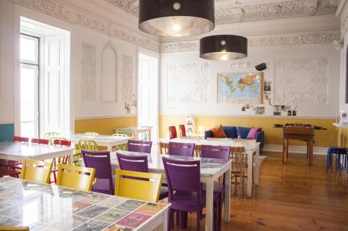 a restaurant with tables and chairs and a room with yellow walls at Lisb'on Hostel in Lisbon