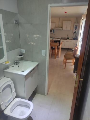 a bathroom with a toilet and a sink and a kitchen at Belgrano 658 Nqn - Piso 1 Dto 2 in Neuquén