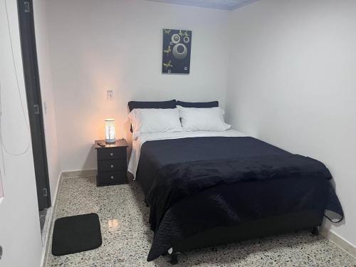 a bedroom with a bed and a night stand with a speaker at Edificio SantaMarta Medellín in Medellín