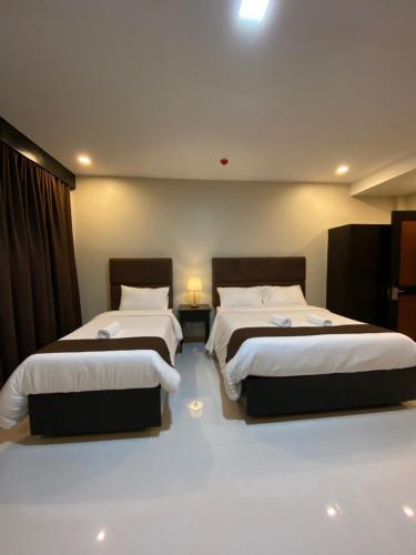 two beds in a hotel room with two beds sidx sidx sidx at Eight Breeze in Baclayon