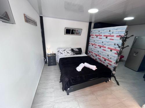 a bedroom with a black bed and a wall at Edificio SantaMarta Medellín in Medellín