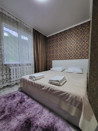 a bedroom with a large bed with a purple rug at Кольсайские озера, гостиница Айару in Kurmenty