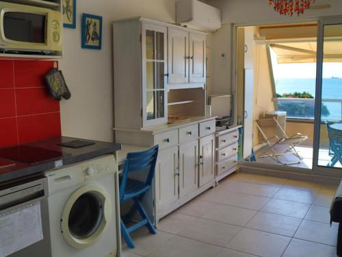 une cuisine avec un lave-linge et un micro-ondes dans l'établissement Studio climatisé avec parking, en front de mer à Sète - FR-1-472A-265, à Sète