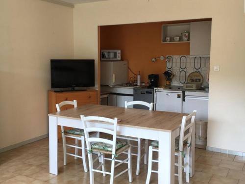 une cuisine avec une table et des chaises et une télévision dans l'établissement T1 Climatisé au Port de Hyères avec Véranda meublée, proche Plages et Commerces - FR-1-335-186, à Hyères