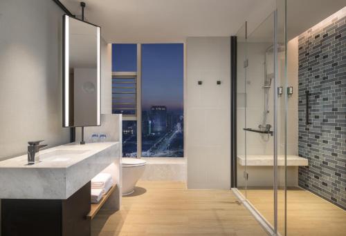 a bathroom with a sink and a toilet and a window at Fairfield by Marriott Dongguan Changping in Dongguan