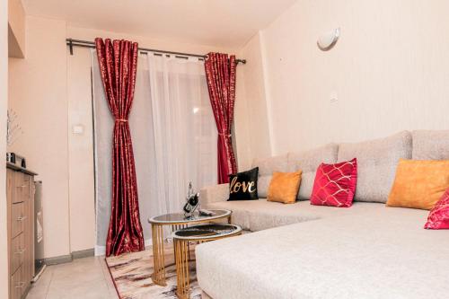 a living room with a couch and red curtains at StayEasy Tsavo in Nairobi