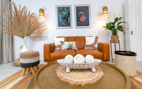 a living room with a couch and a coffee table at Luxury Living In The Heart Of Town, King Bed, 2 Pools, Free WIFI And Undercover Parking in Port Douglas