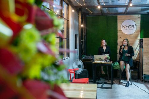 two women sitting at a table in a room at HappyNest Hostel Cebu in Cebu City