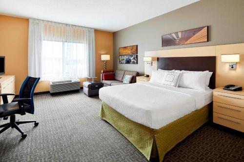 Habitación de hotel con cama grande y escritorio. en TownePlace Suites by Marriott Harrisburg Hershey en Harrisburg