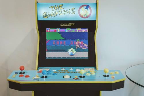 a game room with a video game display on a wall at NYC Loft Inspired •12 mins to WEM •Vintage arcade in Edmonton