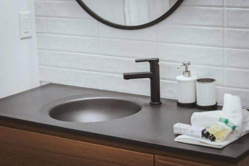 a bathroom counter with a sink and a mirror at NYC Loft Inspired •12 mins to WEM •Vintage arcade in Edmonton