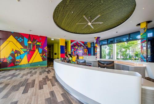 a lobby with a reception counter with colorful walls at Cassia Phuket, part of Banyan Group in Bang Tao Beach