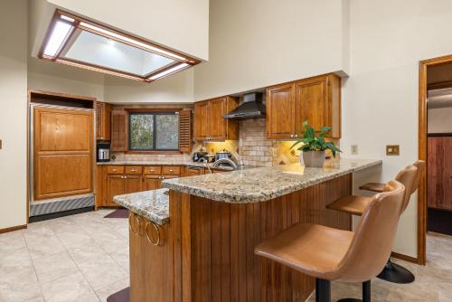 a kitchen with wooden cabinets and a island with stools at Villa Española in San Antonio