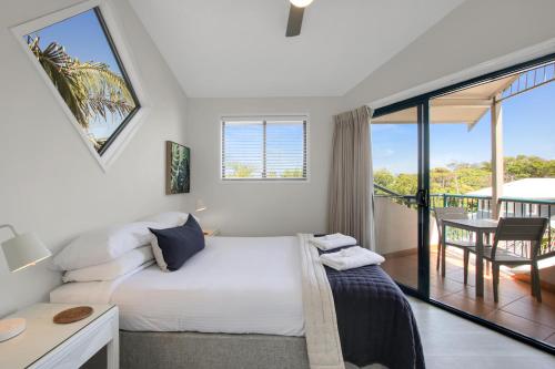 a bedroom with a bed and a balcony at Gosamara Apartments in Byron Bay