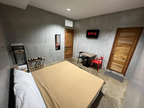 a room with a bed and a table and a desk at HappyNest Hostel Cebu in Cebu City