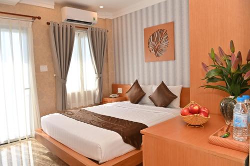 Un dormitorio con una cama y una mesa con fruta. en Trân Châu Beach & Resort, en Bà Rịa