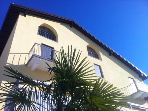 a white building with windows and a palm tree at Casa Bellavista in Pugerna