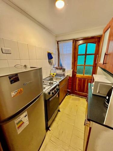 a kitchen with a stainless steel refrigerator and a stove at Casa de veraneo in Los Vilos