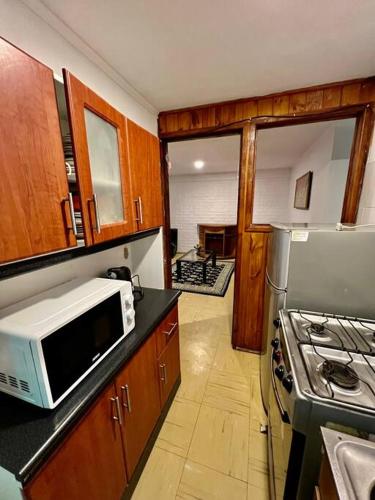 a kitchen with a microwave and a stove at Casa de veraneo in Los Vilos