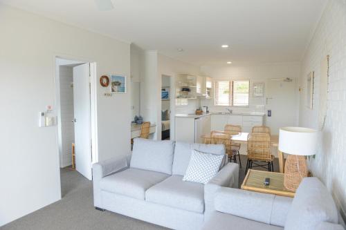 a living room with a white couch and a table at Mollymook Seascape Motel and Apartments in Mollymook