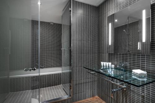 a bathroom with a glass shower and a sink at AC Hotel Milano by Marriott in Milan