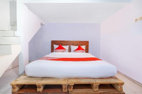 sypialnia z łóżkiem z czerwonymi poduszkami w obiekcie OYO 2415 Ibma Smart Syariah w mieście Pasuruan