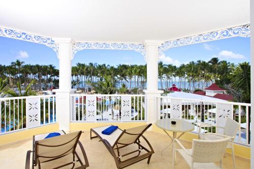 a balcony with chairs and a table and a view of the ocean at Bahia Principe Luxury Bouganville - Adults Only All Inclusive in La Romana