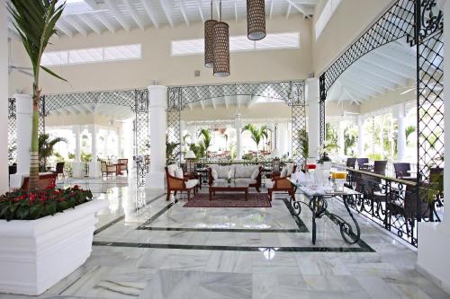 a lobby of a resort with tables and chairs at Bahia Principe Luxury Bouganville - Adults Only All Inclusive in La Romana
