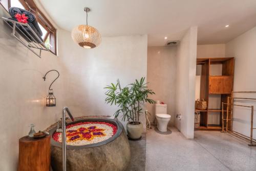 a bathroom with a large pizza in a bath tub at Honai Resort in Ubud