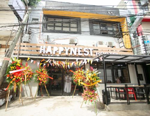 um restaurante com um letreiro feliz em frente a um edifício em HappyNest Hostel Cebu em Cebu