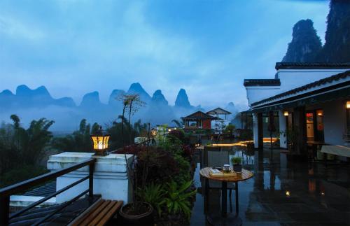 a resort balcony with a view of the mountains at Li-river Island Resort Xingping Yangshuo in Yangshuo
