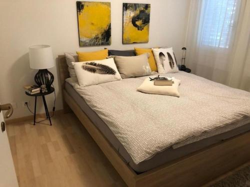 - une chambre dotée d'un grand lit avec des oreillers jaunes et blancs dans l'établissement Exklusive Zweizimmerwohnung mit Pool und Seesicht, à Rovio
