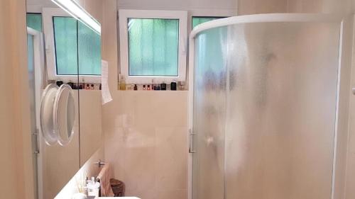 y baño con ducha y lavamanos. en Exklusive Zweizimmerwohnung mit Pool und Seesicht, en Rovio