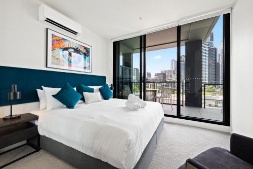 a bedroom with a large bed and a large window at The Marker Apartments Melbourne in Melbourne