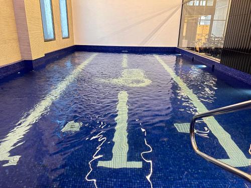 a swimming pool with a cross in the water at Garden Hotel in Kuwait