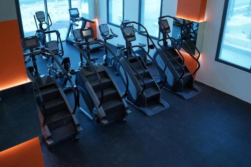 a gym with rows of tread machines in a room at Garden Hotel in Kuwait