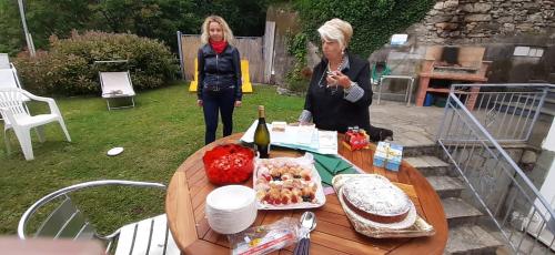 two women standing around a table with food and wine at Da Nonno Vittorio in Vescina