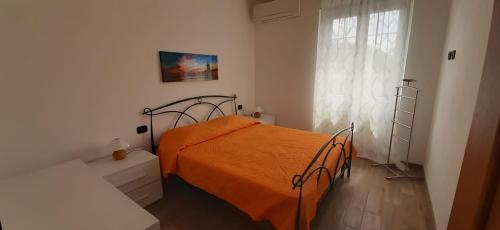 1 dormitorio con 1 cama con manta naranja en Da Nonno Vittorio, en Vescina