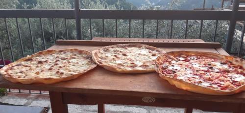 three pizzas sitting on a table on a balcony at Da Nonno Vittorio in Vescina
