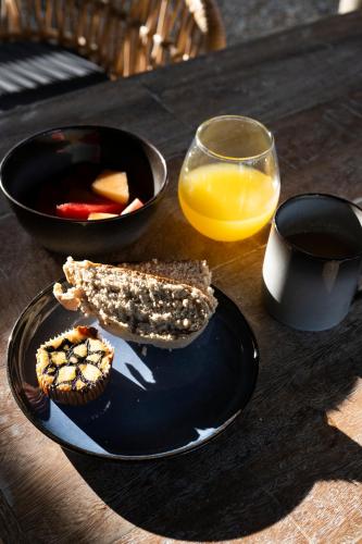 a table with a plate of food and a glass of orange juice at Casa Nemo Beach Resort & Spa in Sabong
