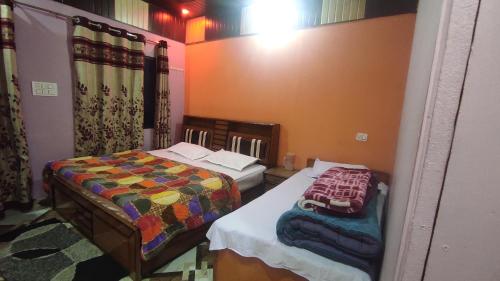 a room with two beds in a room at Laxmi Homes in Sari