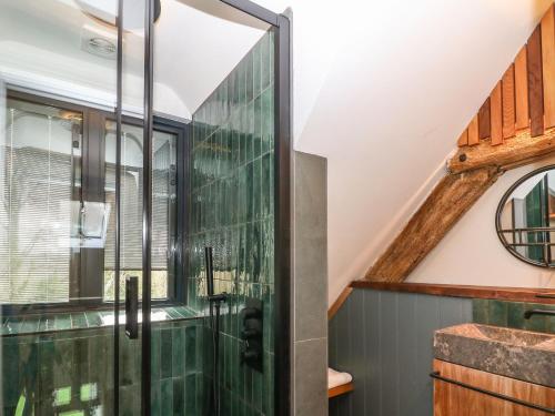 a glass shower in a bathroom with a window at Tickmorend Farm in Stroud