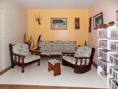 a living room with couches and bookshelves at Pousada Pedacinho de Céu in Abraão