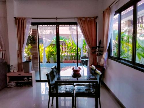 a dining room with a table and chairs and a window at Wilderness in Ban Chang