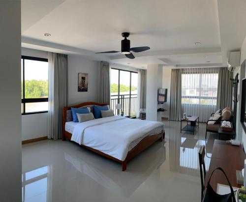 Ban Khlong Tha Thong Lang的住宿－Tamarind ณ บางคล้า ที่พักริมแม่น้ำ，一间卧室设有一张床和一间客厅。