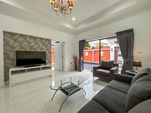 a living room with a couch and a tv at VIEW TALAY VILLAs POOL 119, JOMTIEN BEACH, PATTAYA in Jomtien Beach
