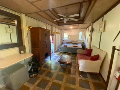 uma sala de estar com uma cama e uma ventoinha de tecto em Thai Heritage Koh Mak em Ko Mak