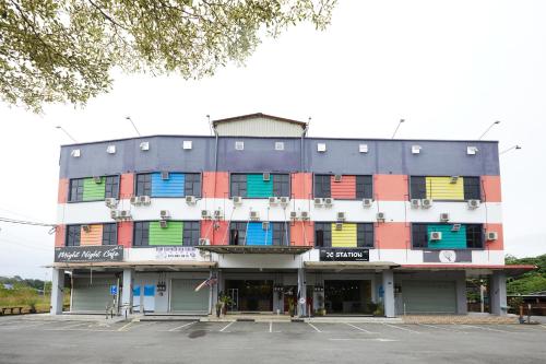 een gebouw met kleurrijke ramen op een parkeerplaats bij SY JERANTUT HOTEL in Jerantut