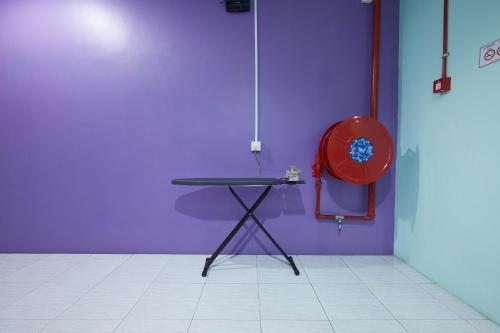 a table and chair in a room with a purple wall at SY JERANTUT HOTEL in Jerantut